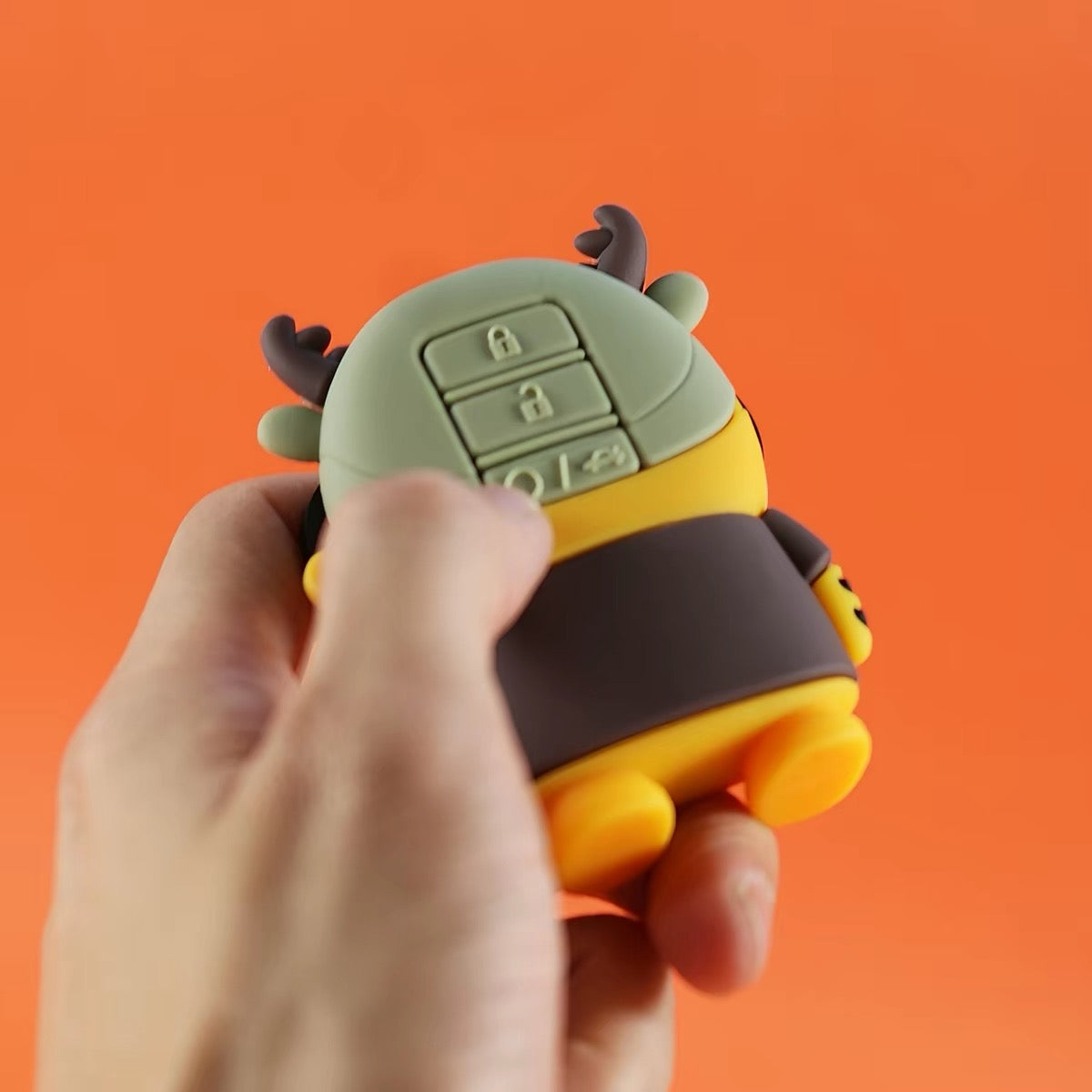 Hand holding tiger key fob cover showing rear button layout